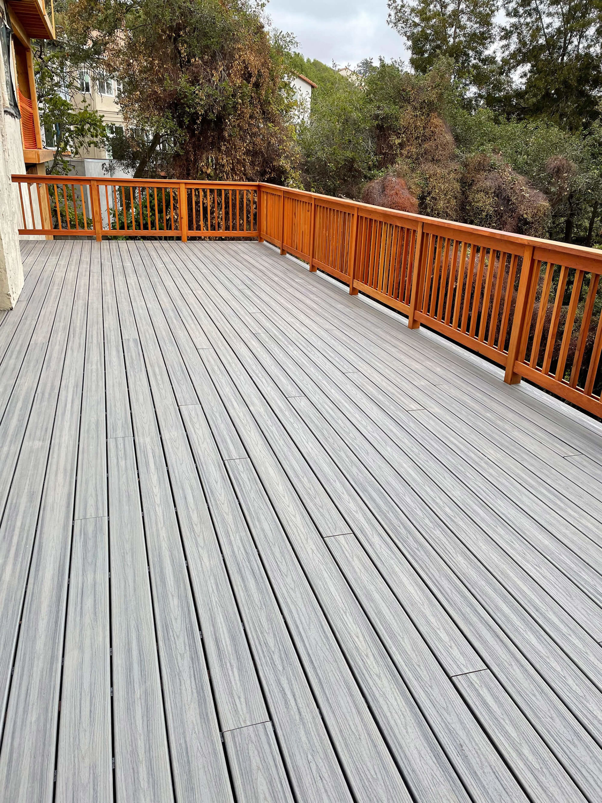 large backyard deck installation with smoky decking boards and cedar hand rails